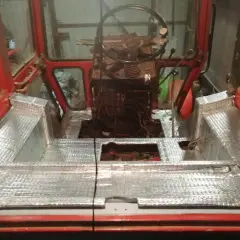 Wnętrze kabiny ciągnika z nałożonym materiałem wygłuszającym. Prace nad wygłuszeniem kabiny ciągnika w toku.