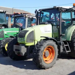 Kilka ciągników rolniczych, w tym zielony John Deere i jasnoszary Claas. Zastanawiasz się, ile motogodzin to dużo dla takiego sprzętu?