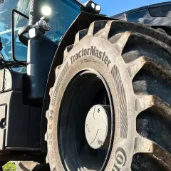 Ciągnik z masywnymi oponami, w tym jedna z napisem "TractorMaster", idealny zamiennik opon rolniczych.