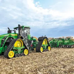 Potężny John Deere 9RX 830 z gąsienicami i pługiem na jesiennym polu.