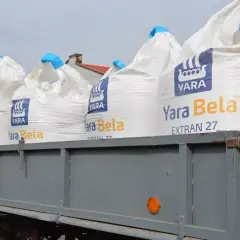 Na przyczepie stoją worki nawozu Yara Bela EXTRAN 27. Właściwe saletrzak dawkowanie zapewni plonom optymalny wzrost.