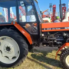 Pomarańczowy Ursus C-362 de luxe, klasyk rolnictwa, prezentowany na wystawie.