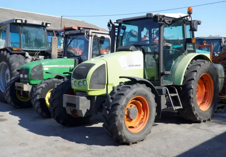 Kilka ciągników rolniczych, w tym zielony John Deere i jasnoszary Claas. Zastanawiasz się, ile motogodzin to dużo dla takiego sprzętu?