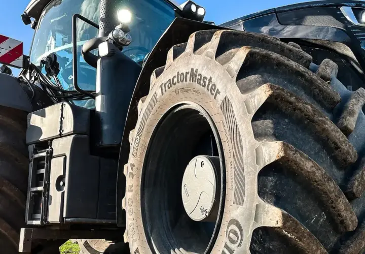 Ciągnik z masywnymi oponami, w tym jedna z napisem "TractorMaster", idealny zamiennik opon rolniczych.