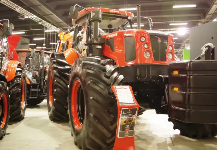 Największy Ursus, potężny traktor o pomarańczowej kabinie i masywnych oponach, prezentuje swoją siłę na targach.