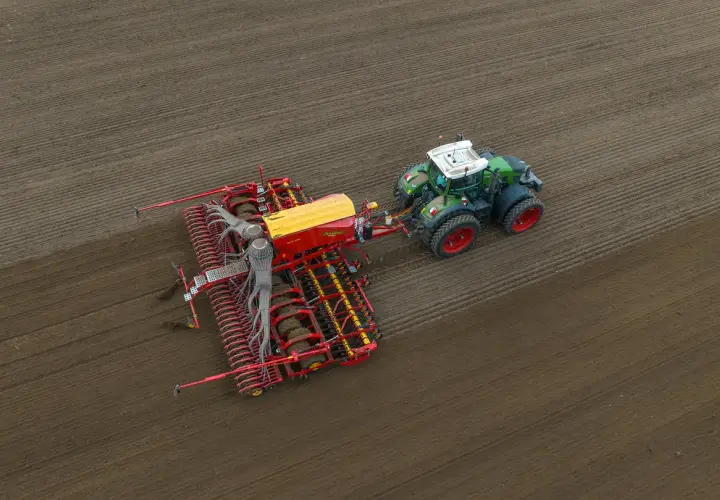 Traktor z siewnikiem w akcji. Idealny moment, kiedy siać pszenżyto, by uzyskać najlepsze plony.