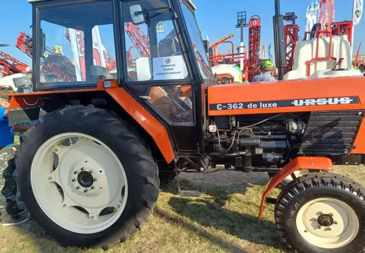 Pomarańczowy Ursus C-362 de luxe, klasyk rolnictwa, prezentowany na wystawie.