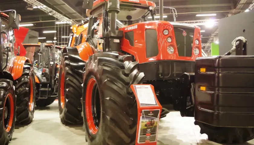 Największy Ursus, potężny traktor o pomarańczowej kabinie i masywnych oponach, prezentuje swoją siłę na targach.