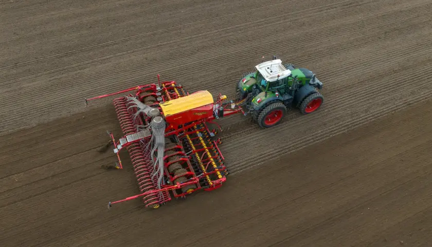 Traktor z siewnikiem w akcji. Idealny moment, kiedy siać pszenżyto, by uzyskać najlepsze plony.
