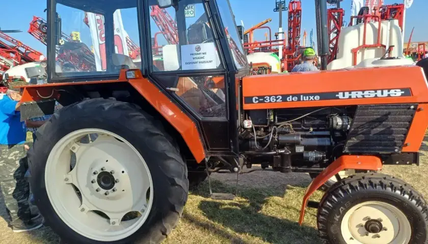 Pomarańczowy Ursus C-362 de luxe, klasyk rolnictwa, prezentowany na wystawie.