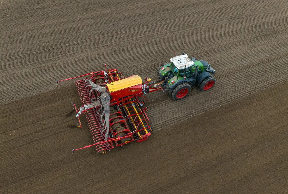 Traktor z siewnikiem w akcji. Idealny moment, kiedy siać pszenżyto, by uzyskać najlepsze plony.