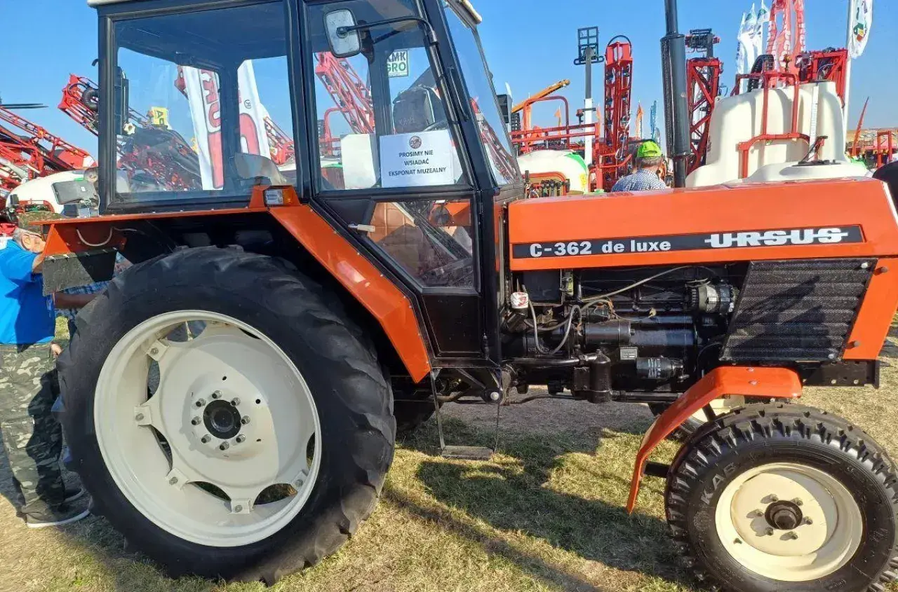 Pomarańczowy Ursus C-362 de luxe, klasyk rolnictwa, prezentowany na wystawie.